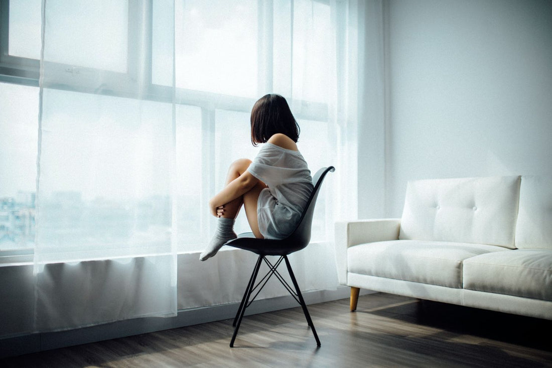 a girl sitting on the chair by holding her knees Photo by Anthony Tran on Unsplash