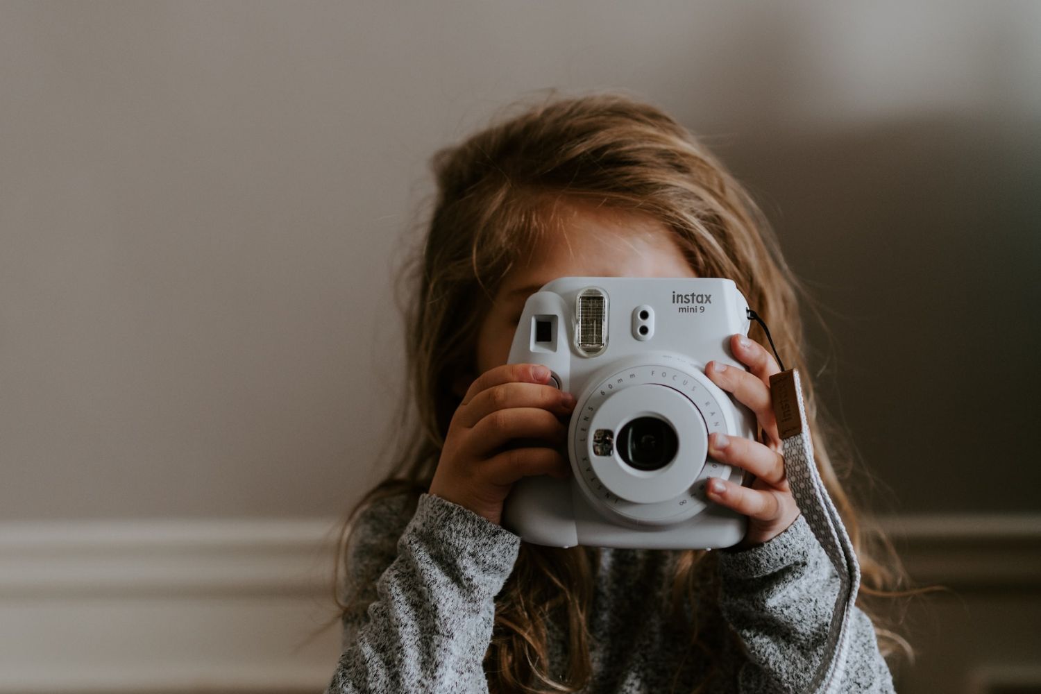 little girl taking photo with a  kids polaroid camera by Kelly Sikkema on Unsplash