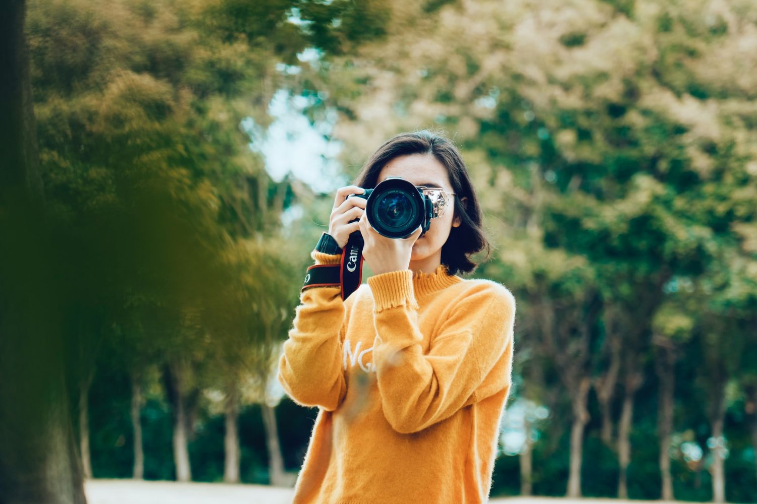 a girl holding a mirrorless camera and taking photo