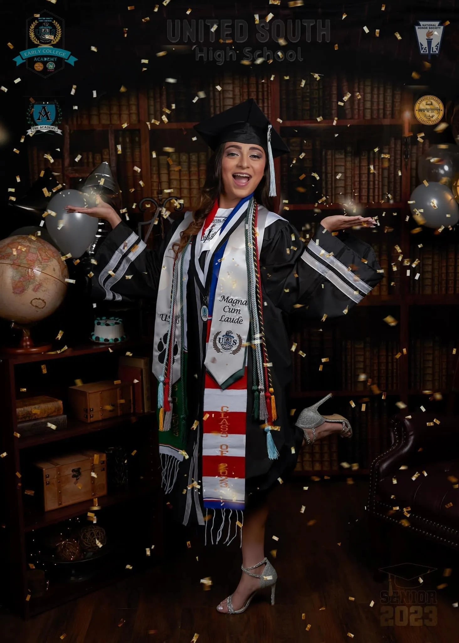 A female college graduate celebrating with falling confetti, two arms extended and one leg lifted behind her, in front of a vintage library bookshelf graduation backdrop.