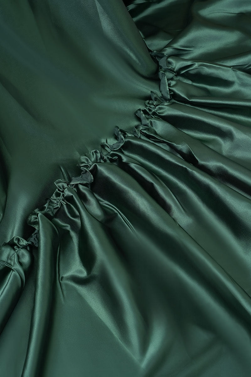 Detail shot of green one-shoulder silk maternity maxi dress