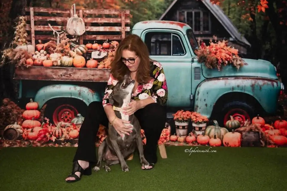 Herfsttruck met gouden bladeren bij oud huis achtergrond ontworpen door Chain Photography