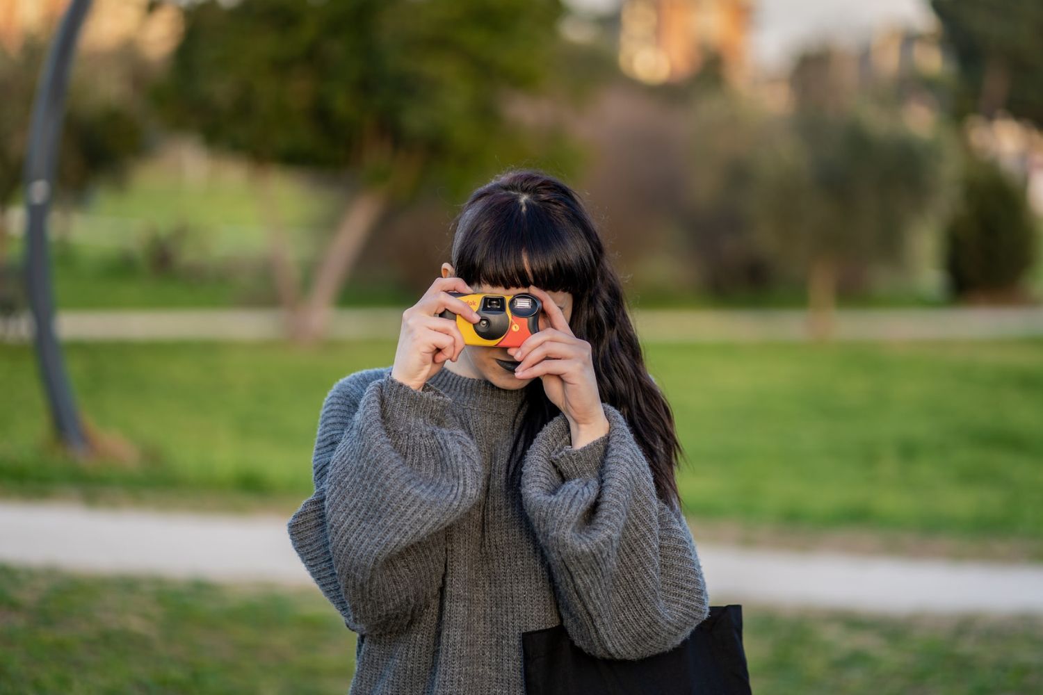 a girl taking photo with a disposable camera