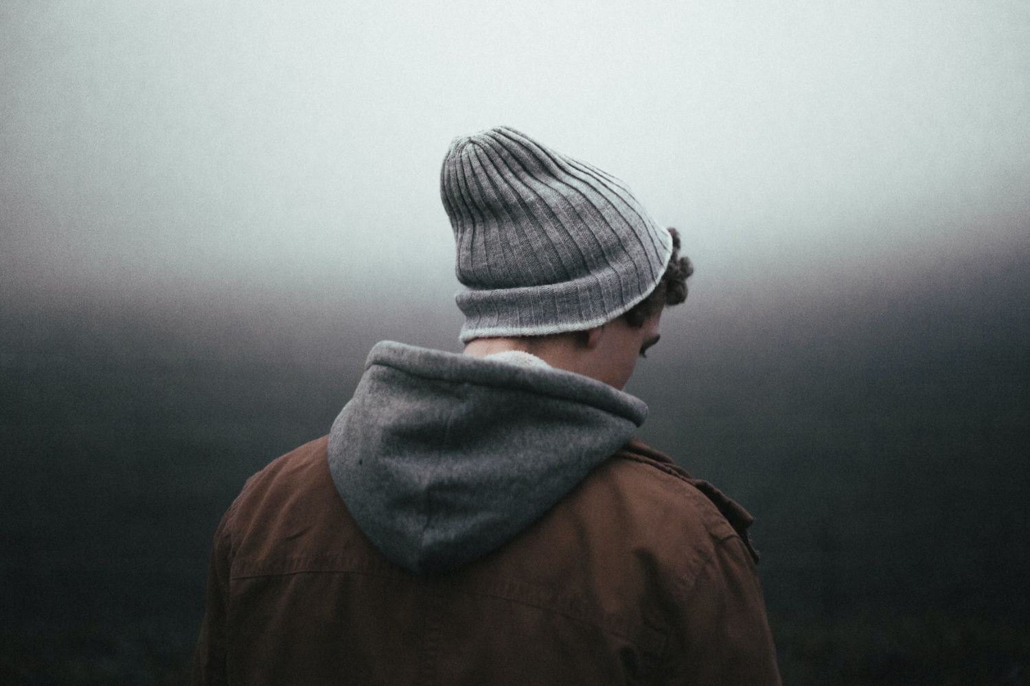 back of a man standing in fog Photo by Andrew Neel on Unsplash