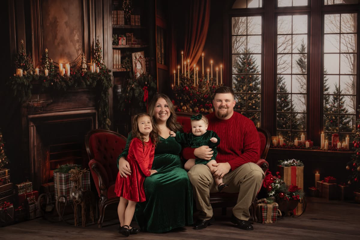 Family of four sitting together for their Christmas holiday themed session
