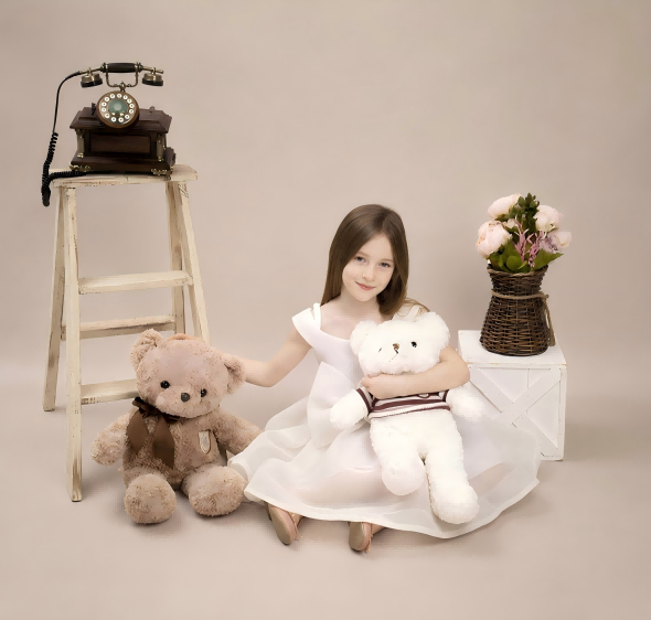 Girl in a white dress sitting with teddy bears in a soft vintage portrait setup.