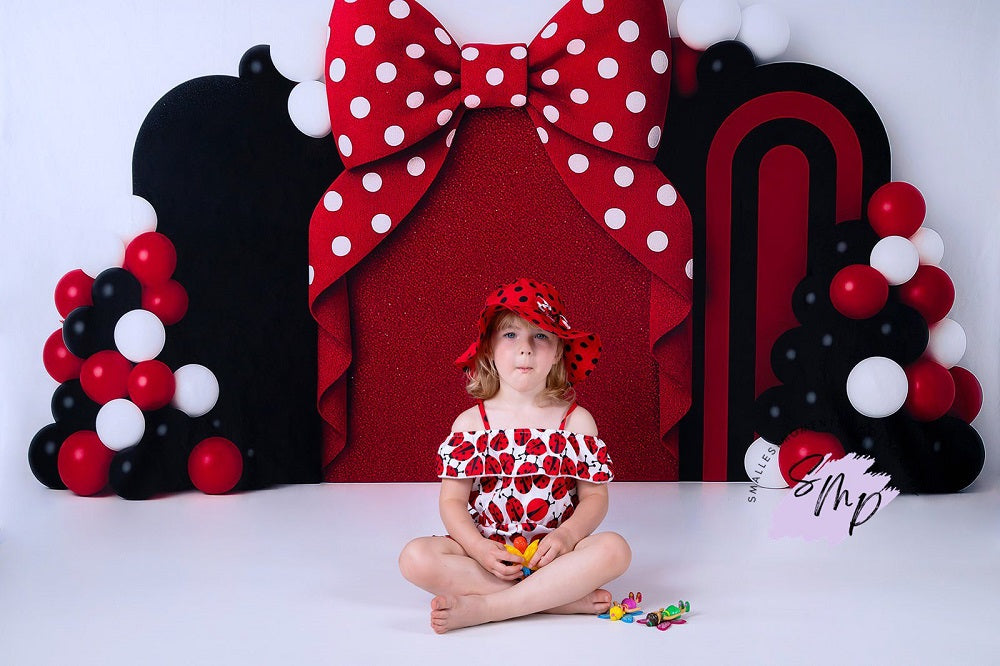 Arco de globos con lazo rojo diseñado por Ashley Paul