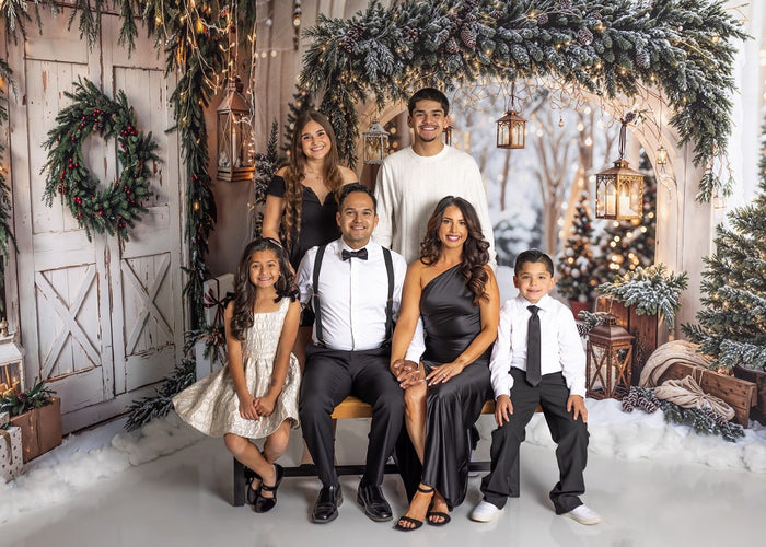 Family portrait in a Christmas snow trees and barn door room set