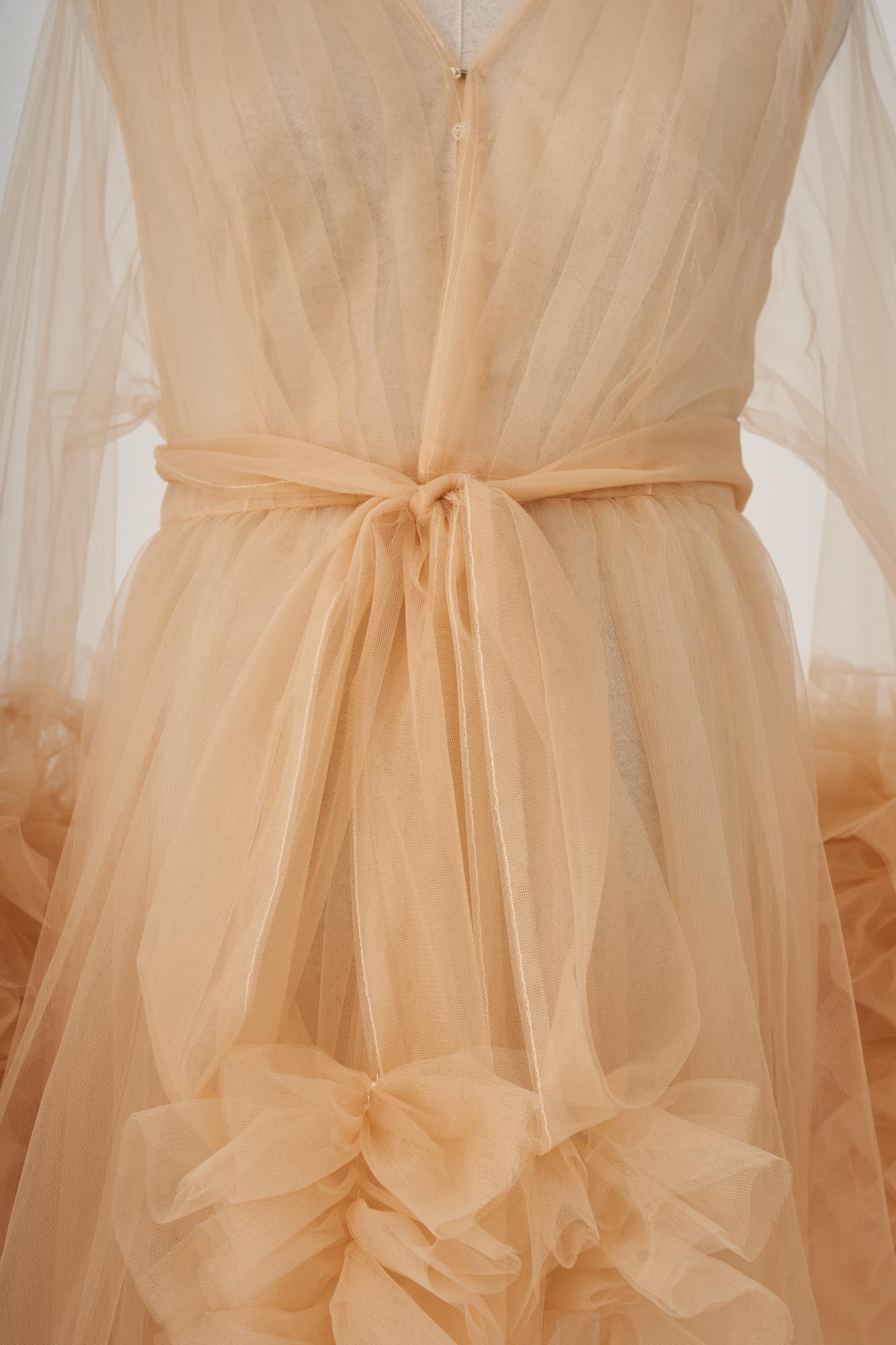 Detail shot of the back of a yellow flared sleeve tulle ruffle maternity dress