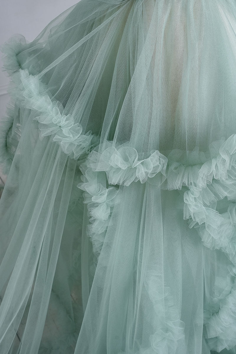 Detail shot of the hemline of the mint green one shoulder mesh maternity dress