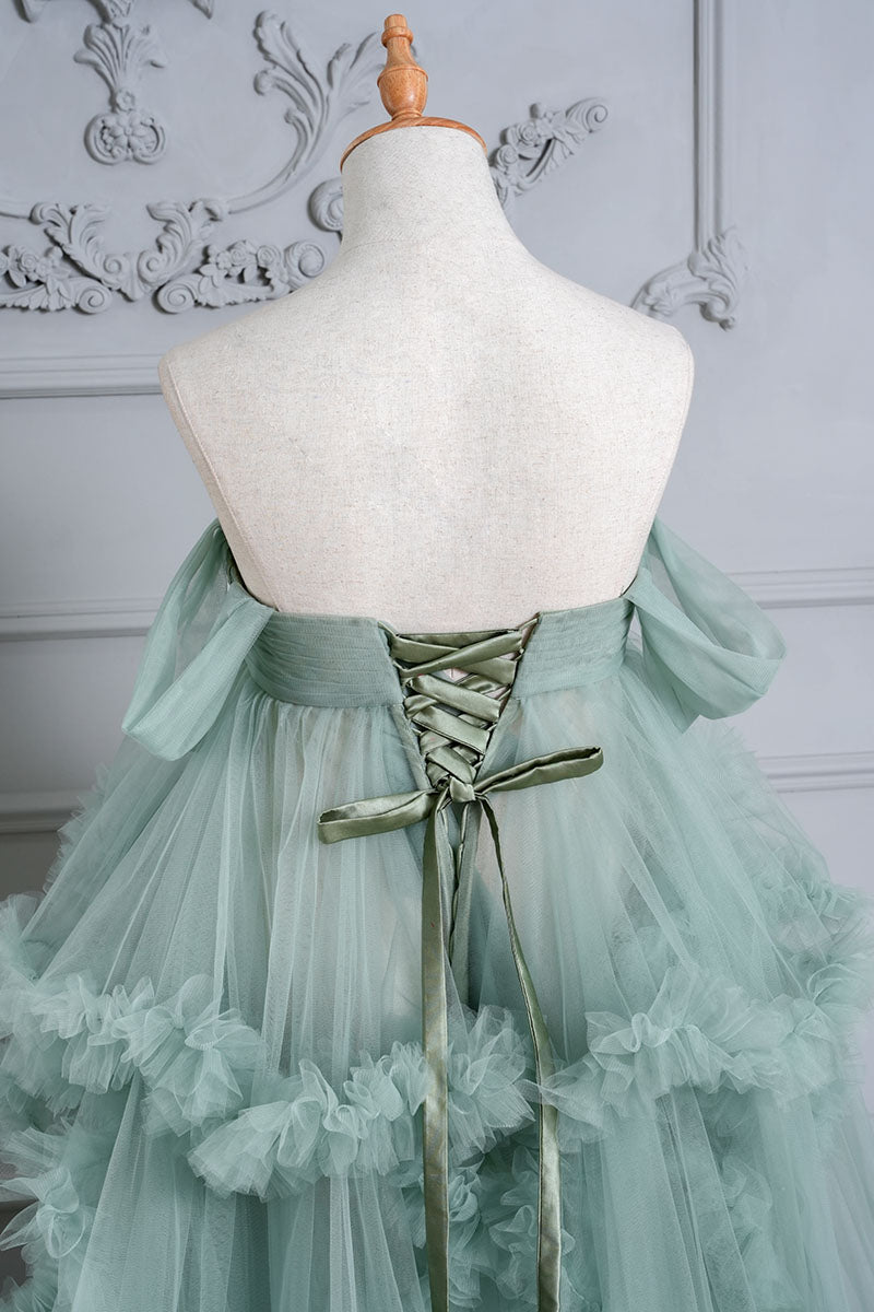 Detail shot of the back of a mint green one-shoulder mesh maternity dress