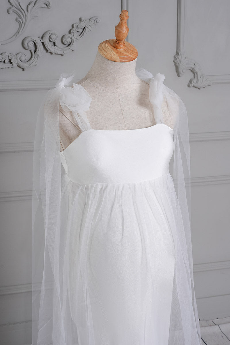 Detail shot of the front of a white one-shoulder mesh maternity dress